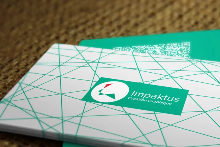 Carte de visite d'IMPAKTUS CREATION GRAPHIQUE, posée sur un fond clair : fond blanc couvert d'un maillage de triangles verts, logo vert avec le « i » et l'éclat rouge