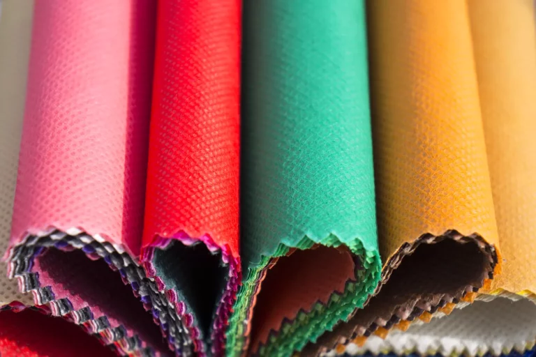 Rouleaux de tissu aux couleurs vives, rose, rouge, vert et jaune, côte à côte : des échantillons de textile pour l'impression